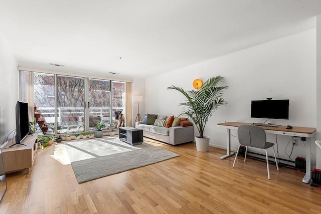 living room featuring floor to ceiling windows and light hardwood / wood-style flooring