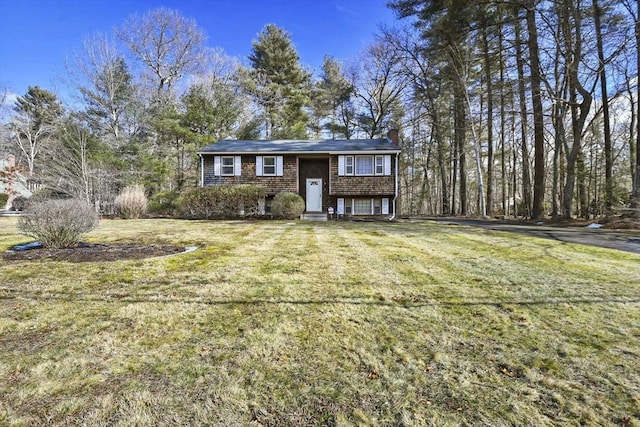 raised ranch with a chimney and a front yard