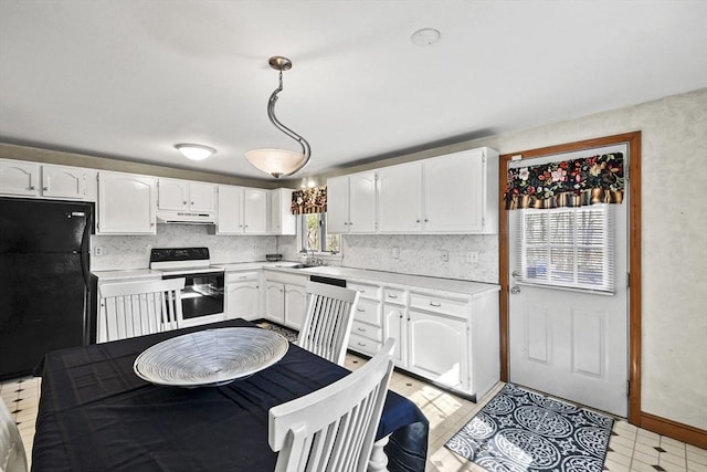 kitchen with light countertops, freestanding refrigerator, electric stove, and white cabinets