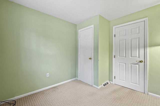 unfurnished bedroom featuring carpet flooring, visible vents, and baseboards