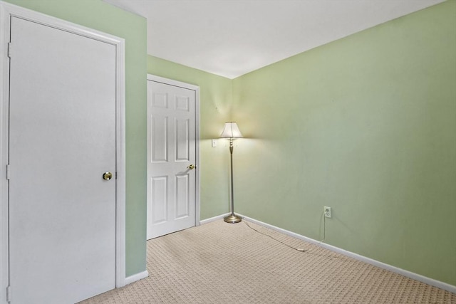 unfurnished room featuring carpet floors and baseboards