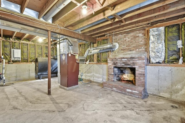 unfinished basement featuring heating fuel, an outdoor brick fireplace, and electric panel