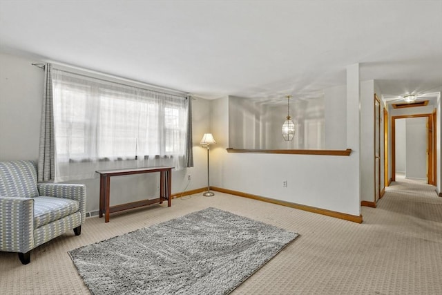 sitting room featuring carpet flooring and baseboards