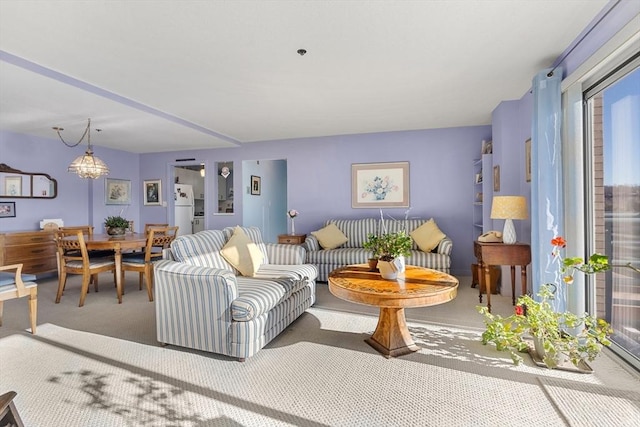 carpeted living room featuring a chandelier