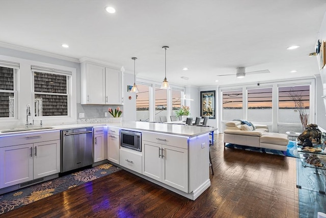 131 Dorchester St Unit 131, Quincy, MA 02171 - kitchen with a sink, appliances with stainless steel finishes, a peninsula, dark wood-style flooring, and light countertops
