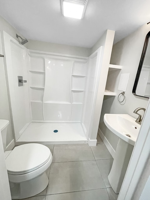 bathroom featuring tile patterned floors, toilet, and walk in shower