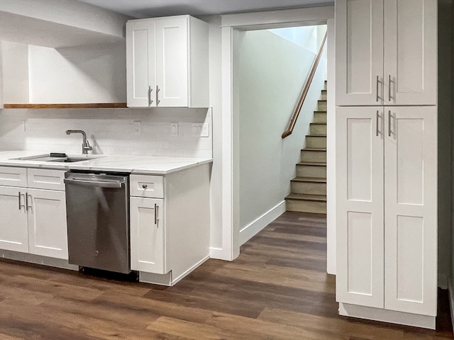 kitchen featuring sink, stainless steel dishwasher, dark wood-type flooring, white cabinetry, and decorative backsplash