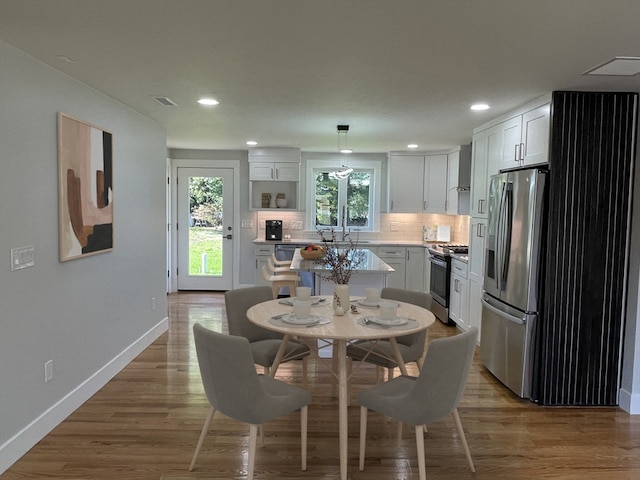 dining space with sink and hardwood / wood-style floors