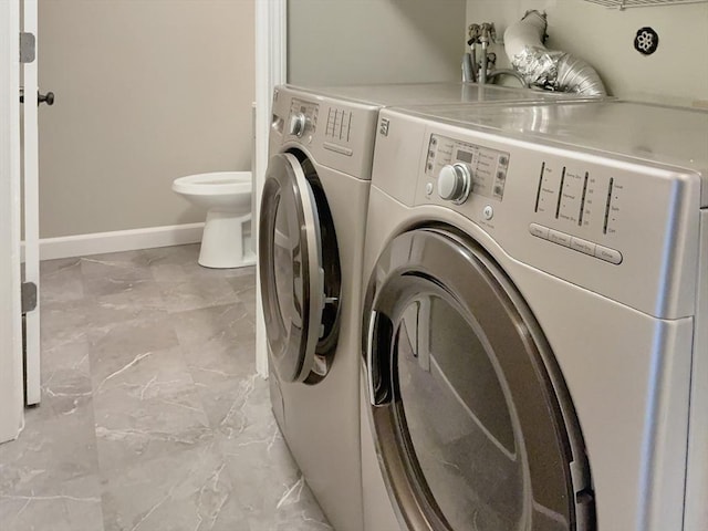 washroom with laundry area, independent washer and dryer, marble finish floor, and baseboards