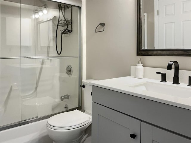 bathroom with toilet, bath / shower combo with glass door, and vanity