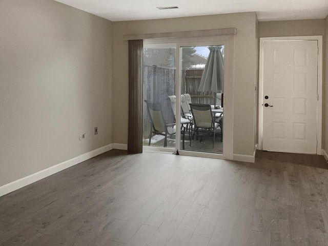 interior space featuring visible vents, baseboards, and wood finished floors