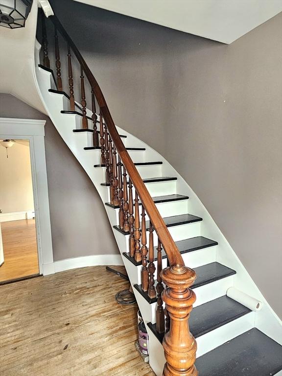 stairs featuring baseboards and wood finished floors