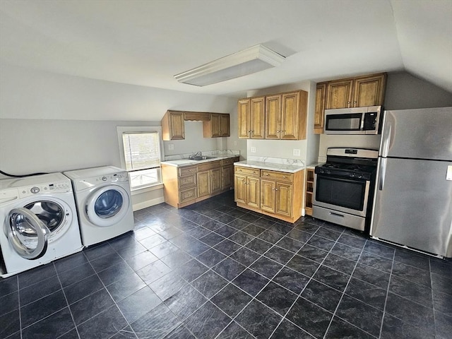 kitchen featuring washing machine and clothes dryer, brown cabinetry, light countertops, and stainless steel appliances