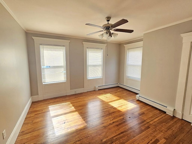 spare room featuring a baseboard radiator, hardwood / wood-style floors, and crown molding