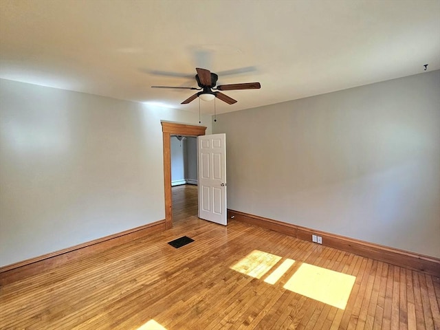 spare room with ceiling fan, baseboards, and hardwood / wood-style floors