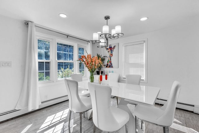 dining space featuring an inviting chandelier, light wood-type flooring, a baseboard radiator, and a wealth of natural light