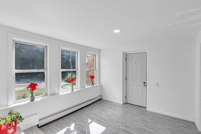 empty room with a baseboard radiator and plenty of natural light