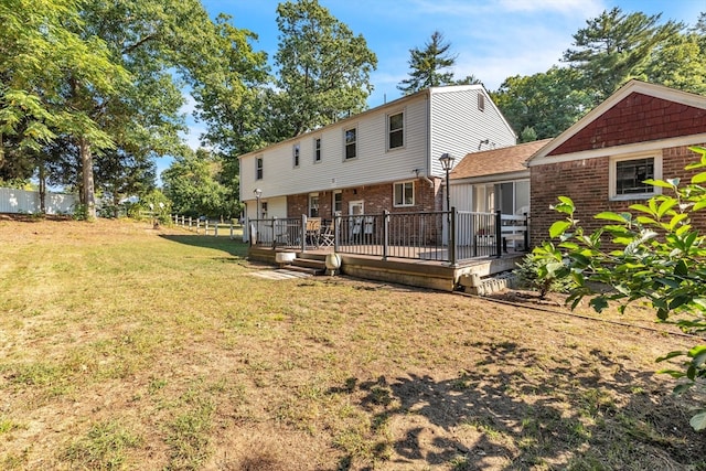 rear view of property with a lawn and a deck