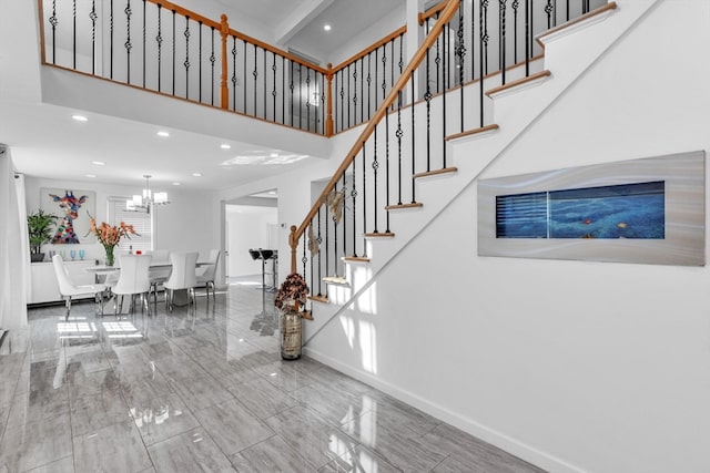 staircase with a notable chandelier