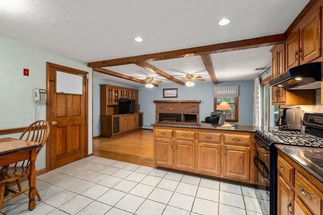 23 Lafayette Dr, Walpole, MA 02032 - kitchen featuring gas stove, under cabinet range hood, a ceiling fan, a brick fireplace, and beamed ceiling