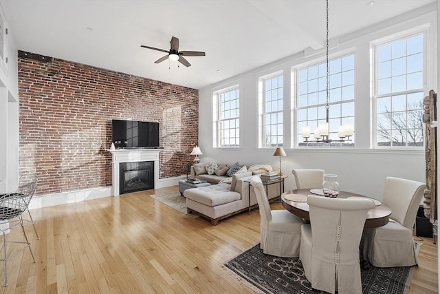 interior space with ceiling fan, light hardwood / wood-style flooring, and brick wall