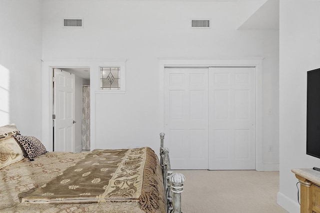 bedroom with light carpet and a closet