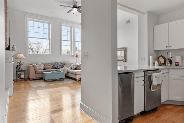 kitchen with light wood-type flooring, white cabinetry, and ceiling fan