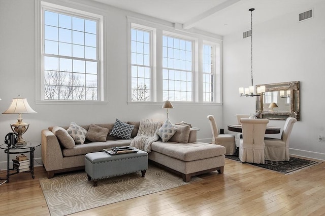 interior space featuring plenty of natural light, an inviting chandelier, and light wood-type flooring