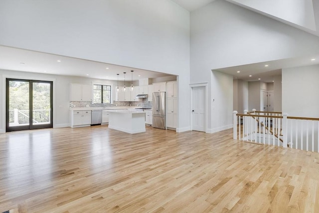 92 Whiffletree Ave, Brewster, MA 02631 - unfurnished living room featuring light wood finished floors, recessed lighting, baseboards, and a high ceiling