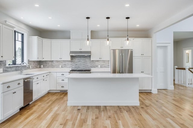 92 Whiffletree Ave, Brewster, MA 02631 - kitchen featuring stainless steel appliances, under cabinet range hood, a sink, decorative backsplash, and white cabinets