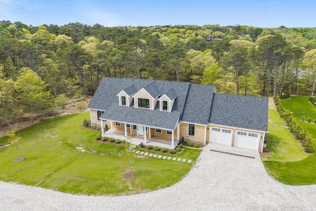 92 Whiffletree Ave, Brewster, MA 02631 - new england style home with covered porch, an attached garage, driveway, and a wooded view