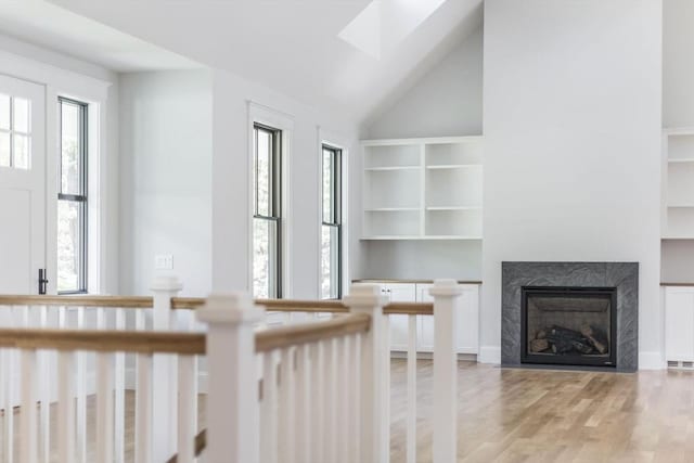 92 Whiffletree Ave, Brewster, MA 02631 - unfurnished living room featuring plenty of natural light, light wood-type flooring, a fireplace, built in features, and lofted ceiling
