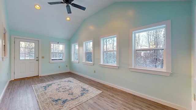 foyer entrance featuring lofted ceiling, ceiling fan, wood finished floors, and baseboards