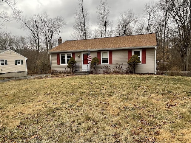 single story home with a chimney and a front yard