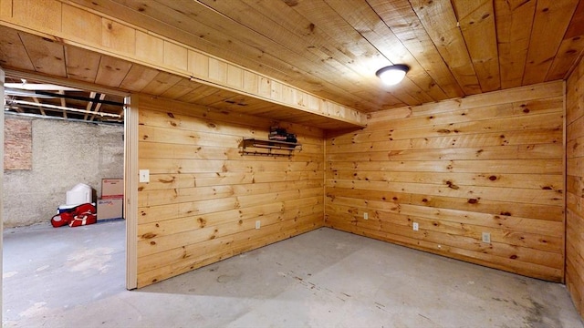 unfurnished room with wood ceiling, wooden walls, and unfinished concrete flooring