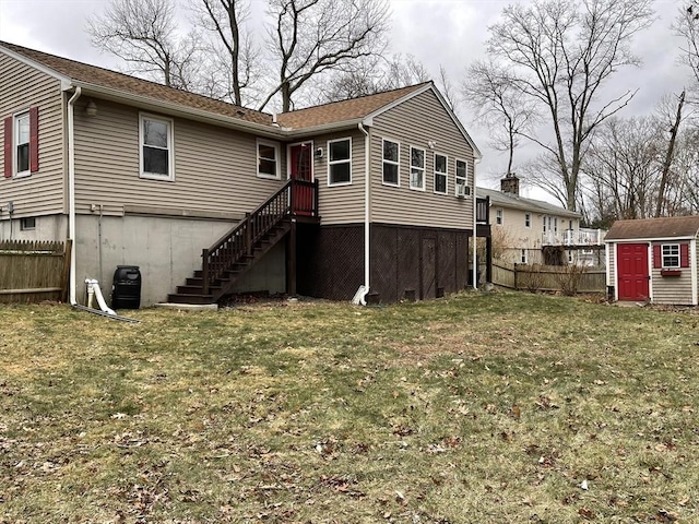 rear view of house with a lawn, a storage shed, fence, an outdoor structure, and stairs