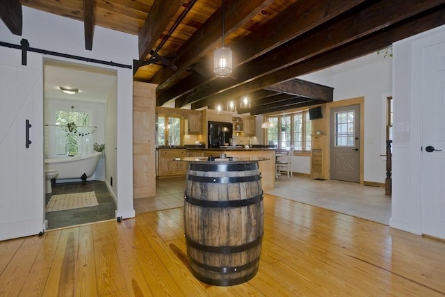 60 Daniel Shays Hwy, Pelham, MA 01002 - bar area featuring light wood-style flooring, a barn door, black fridge, a wood ceiling with exposed beams, and pendant lighting