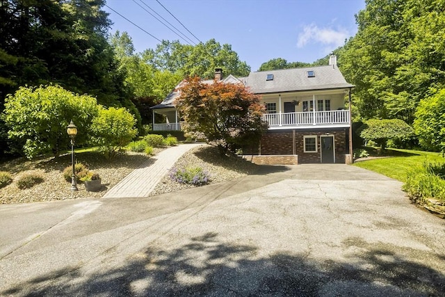 60 Daniel Shays Hwy, Pelham, MA 01002 - view of front facade with a chimney, a porch, and asphalt driveway