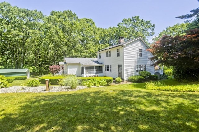 60 Daniel Shays Hwy, Pelham, MA 01002 - back of property featuring a chimney, a sunroom, and a lawn