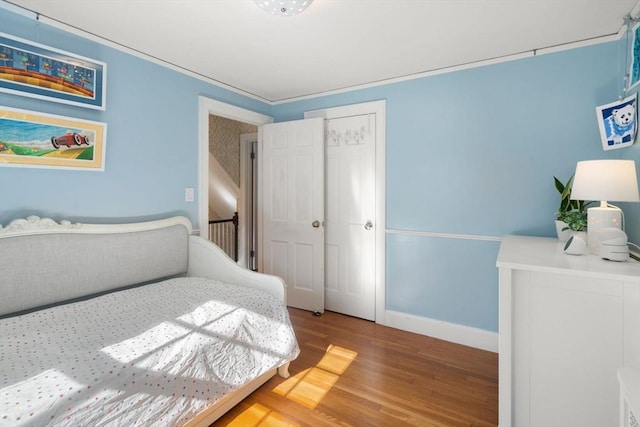 bedroom featuring a closet, baseboards, and wood finished floors