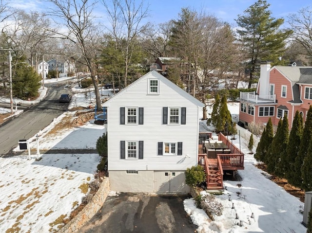 exterior space with a deck, driveway, stairway, a residential view, and a chimney