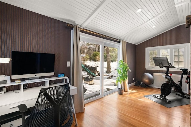 workout room with lofted ceiling and wood finished floors