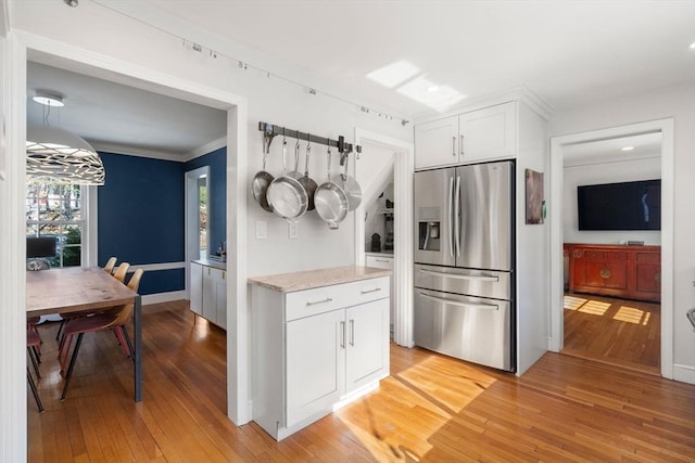 kitchen with light wood-style flooring, white cabinets, crown molding, and stainless steel fridge with ice dispenser