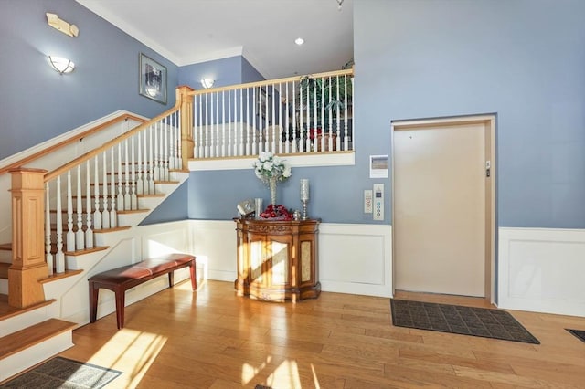 entrance foyer with ornamental molding and hardwood / wood-style flooring