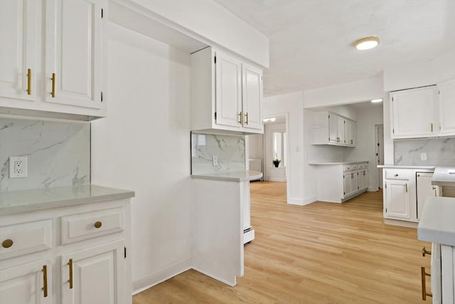 kitchen with light wood-style flooring and white cabinets