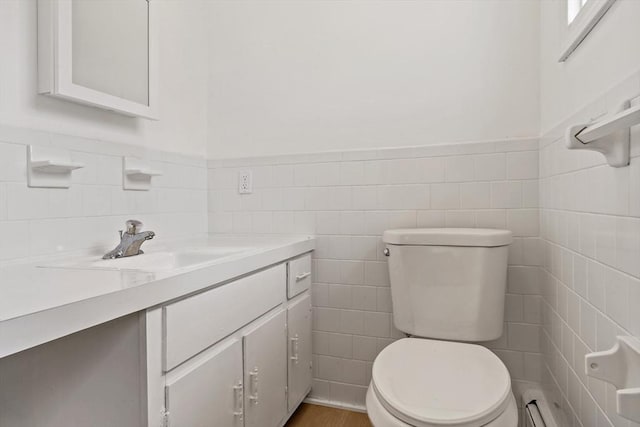 half bathroom featuring a wainscoted wall, vanity, and toilet