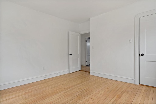 unfurnished room with baseboards and hardwood / wood-style floors