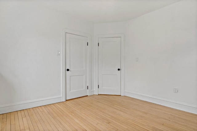 unfurnished room with light wood-style flooring and baseboards