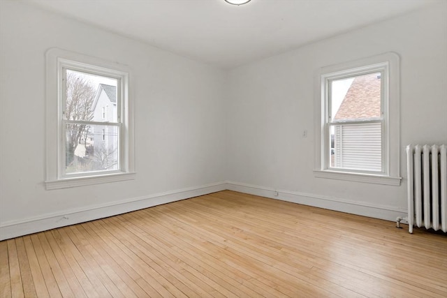 spare room with hardwood / wood-style flooring and radiator