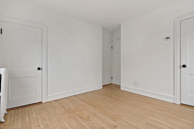 unfurnished bedroom featuring hardwood / wood-style flooring and baseboards